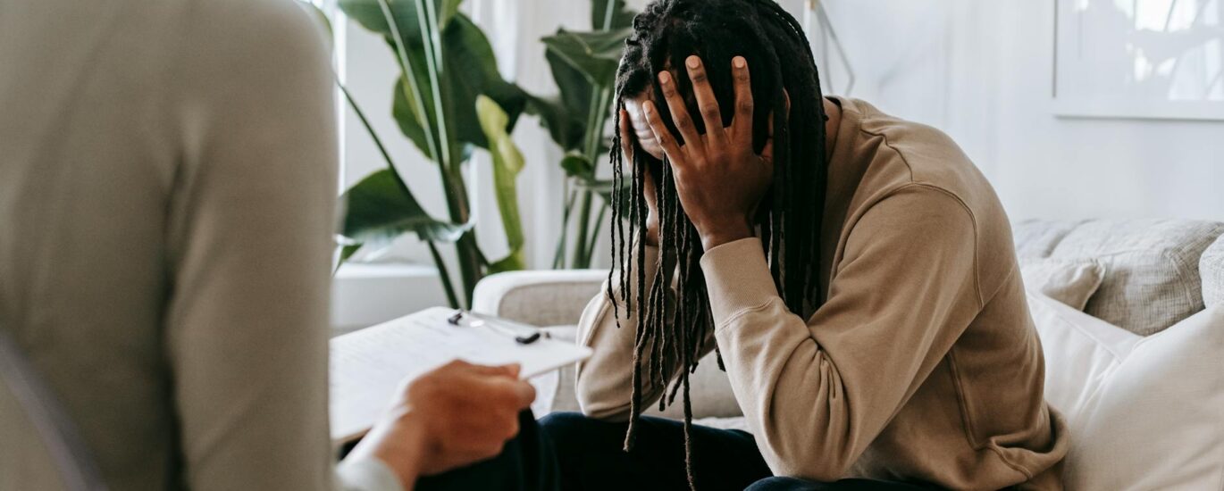 stressed black man with dreadlocks in psychological office
