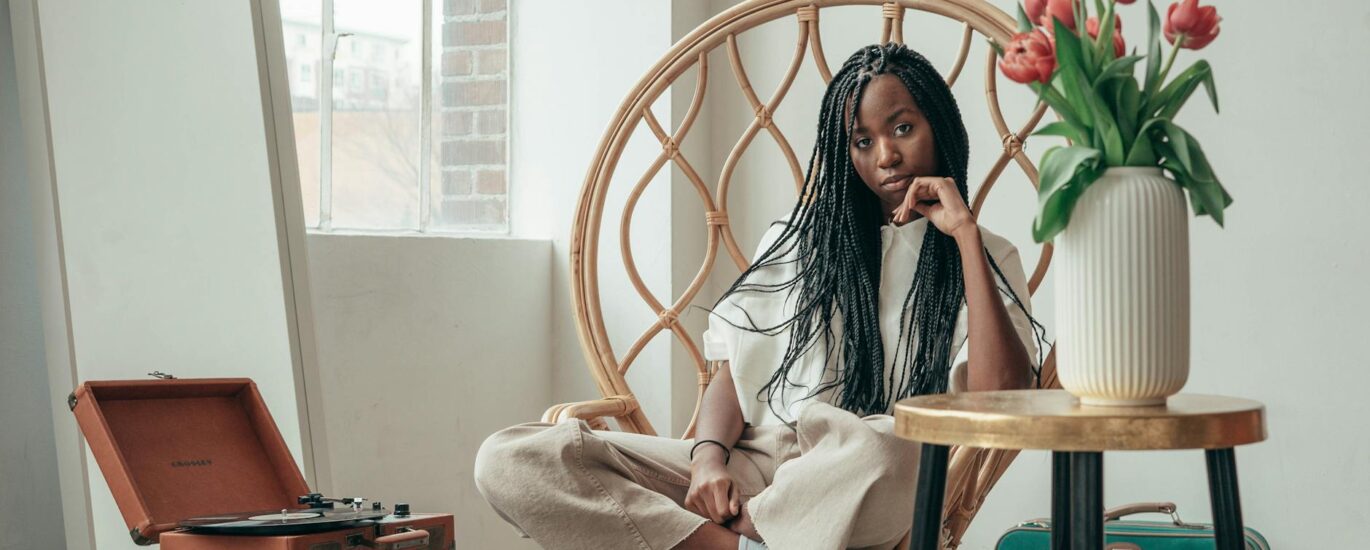 tranquil young black woman listening to songs via vinyl record at home