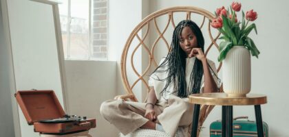 tranquil young black woman listening to songs via vinyl record at home