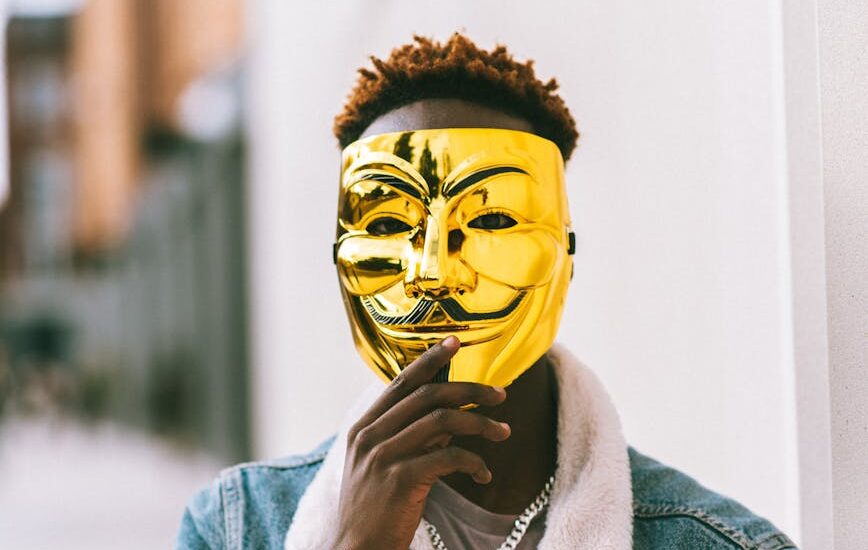 black man covering face with anonymous mask