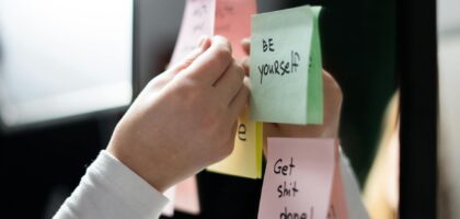 person holding white and pink sticky notes
